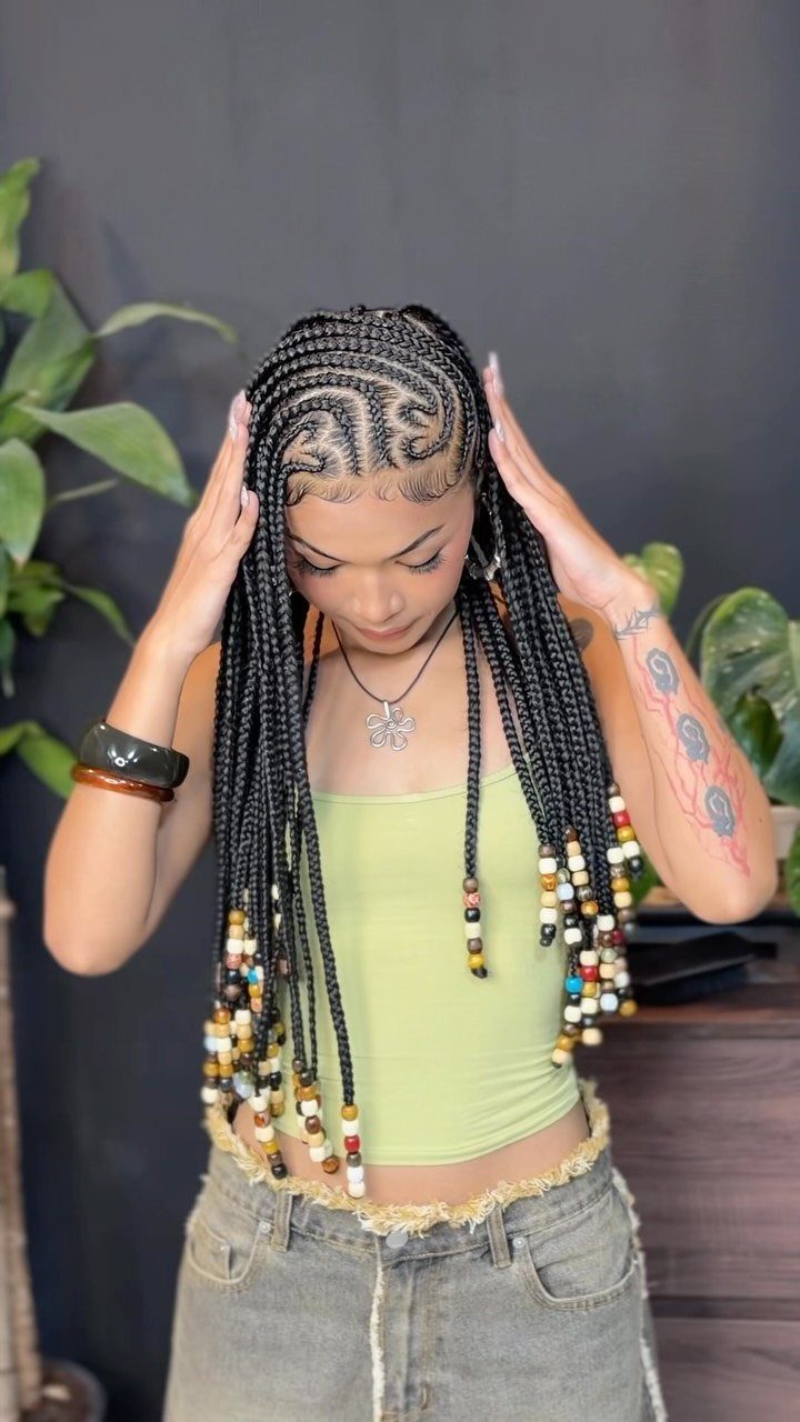 Woman with Fulani braids featuring scalp cornrows and colorful beads on loose braids.