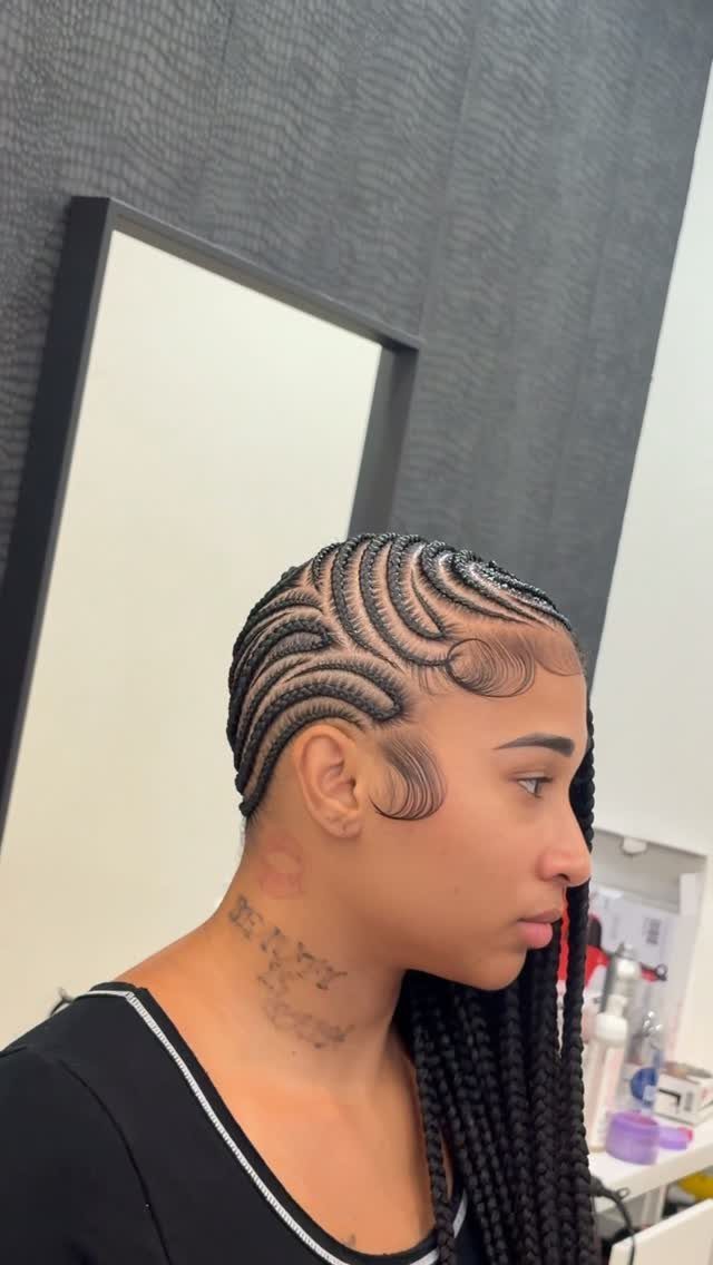 Woman with side-swept lemonade braids styled in curved cornrows falling to one side.