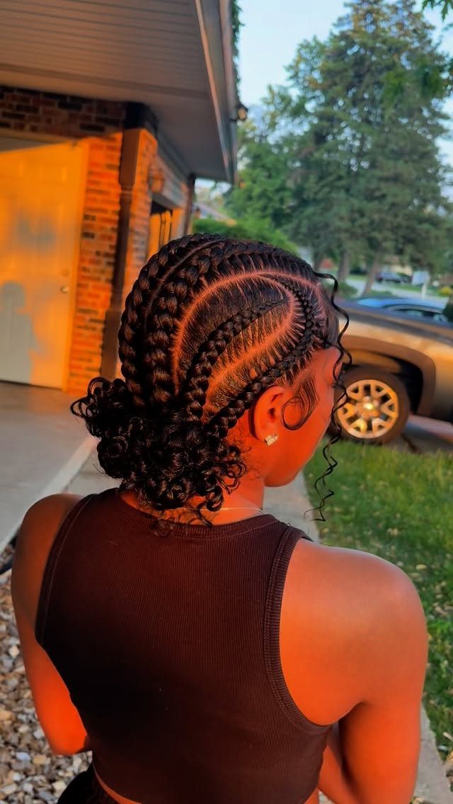 Woman with cornrow braids to the scalp gathered into a curly low bun.