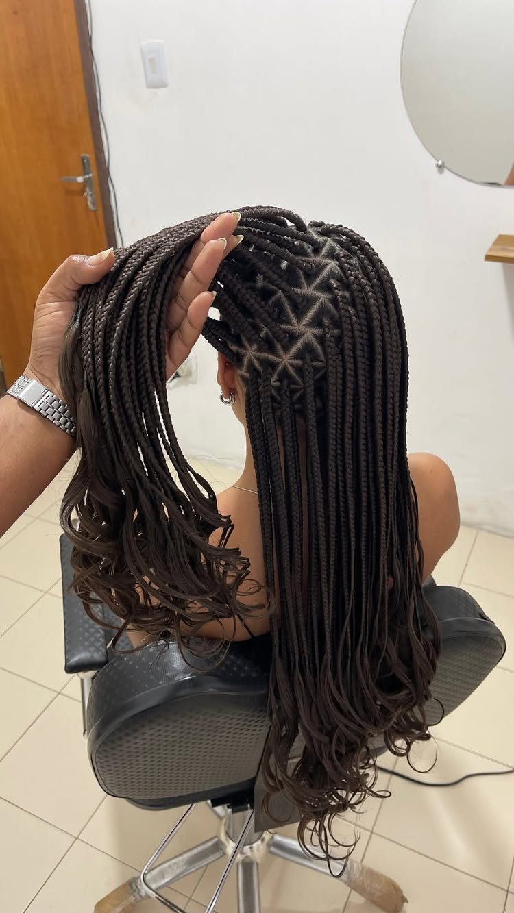 Long dark brown braids with a geometric star-shaped parting pattern on the scalp.
