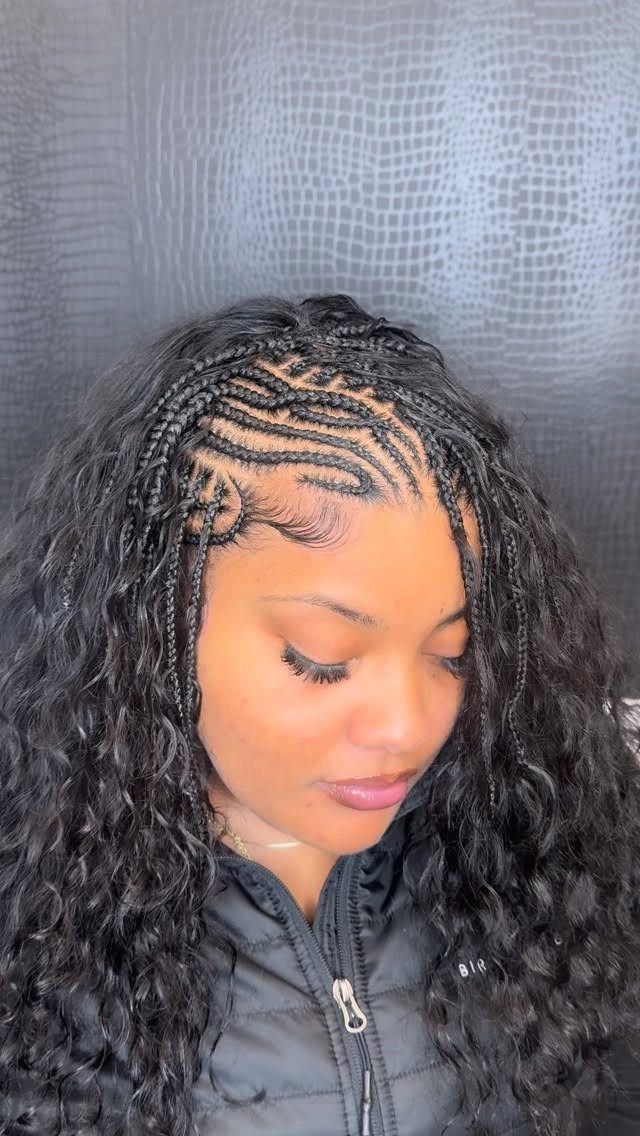 Woman with cornrows braided to the scalp and long loose curly black hair.