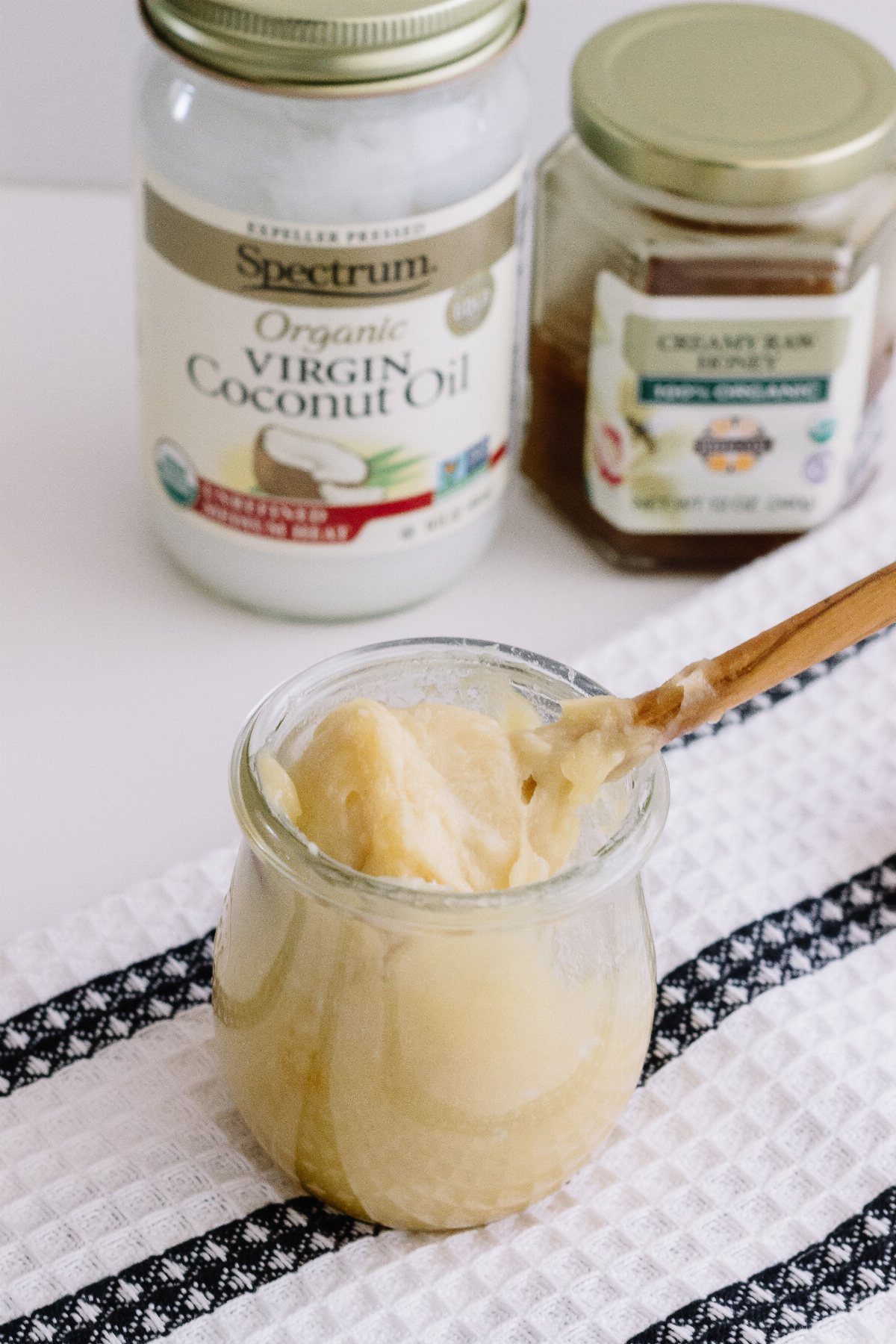 Creamy hair mask in a glass jar with coconut oil and honey jars.