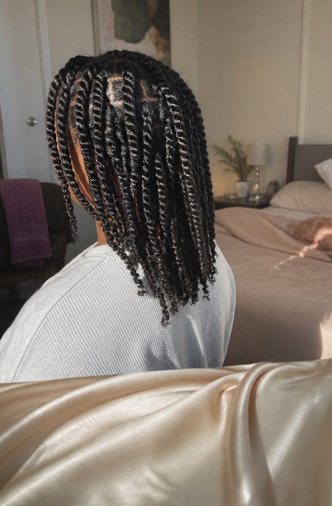 Coily hair arranged in loose two-strand twists with soft flyaways