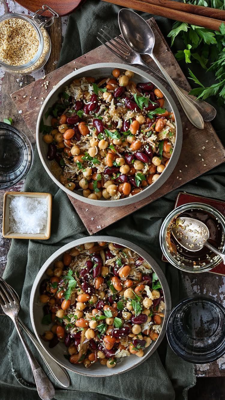 Chickpea and kidney bean salad with grains and herbs in grey bowls.