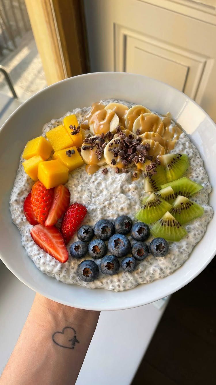 Chia seed pudding bowl topped with fresh berries, kiwi, mango, and banana slices.