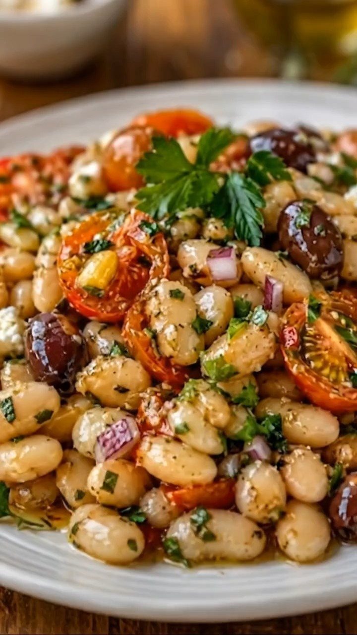White bean salad with cherry tomatoes, olives, red onion, and fresh parsley.