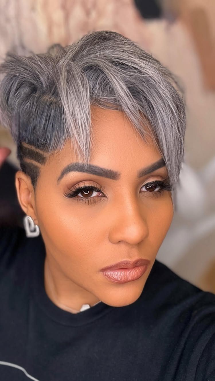 Woman with a silver and gray pixie cut and shaved side profile.