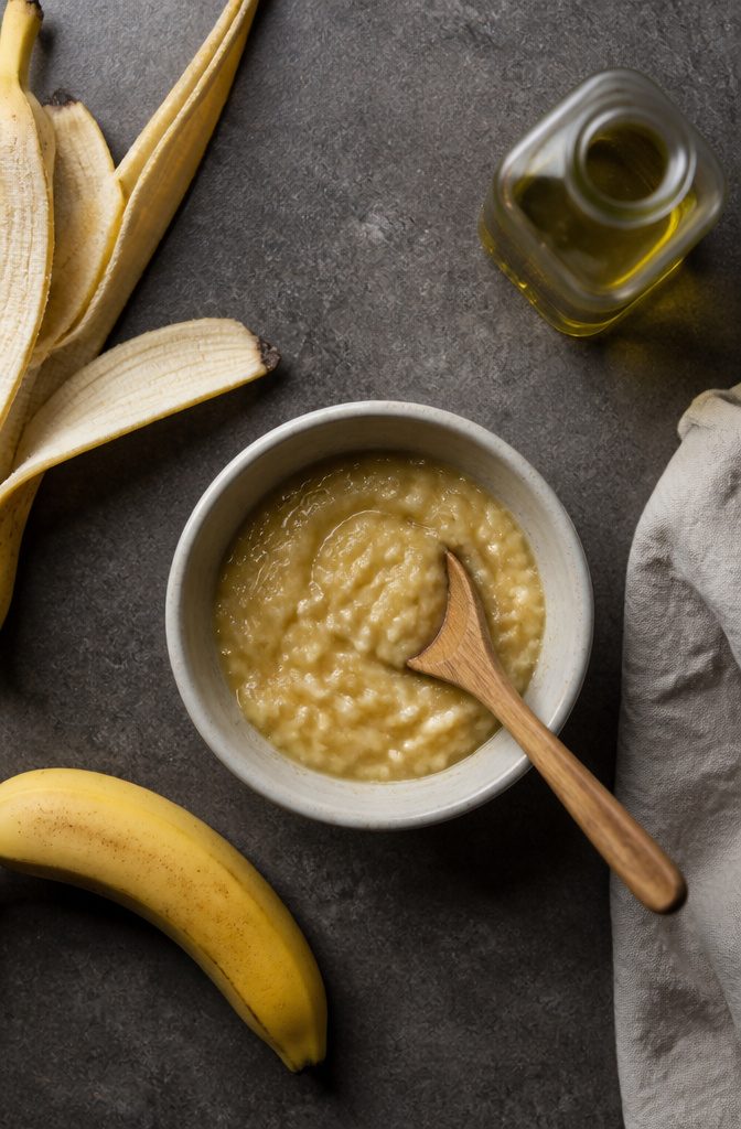 Smooth mashed banana and olive oil in a mixing bowl