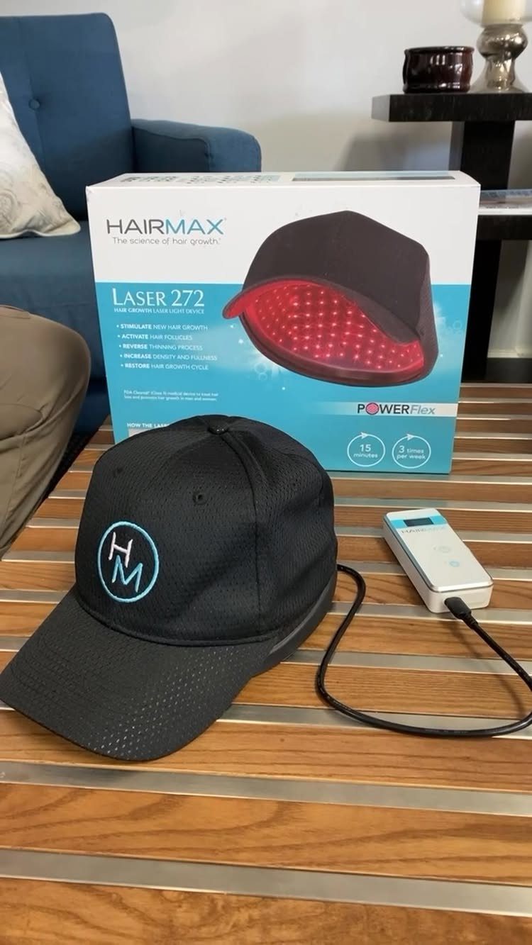 Black laser hair growth cap and power device next to product packaging.
