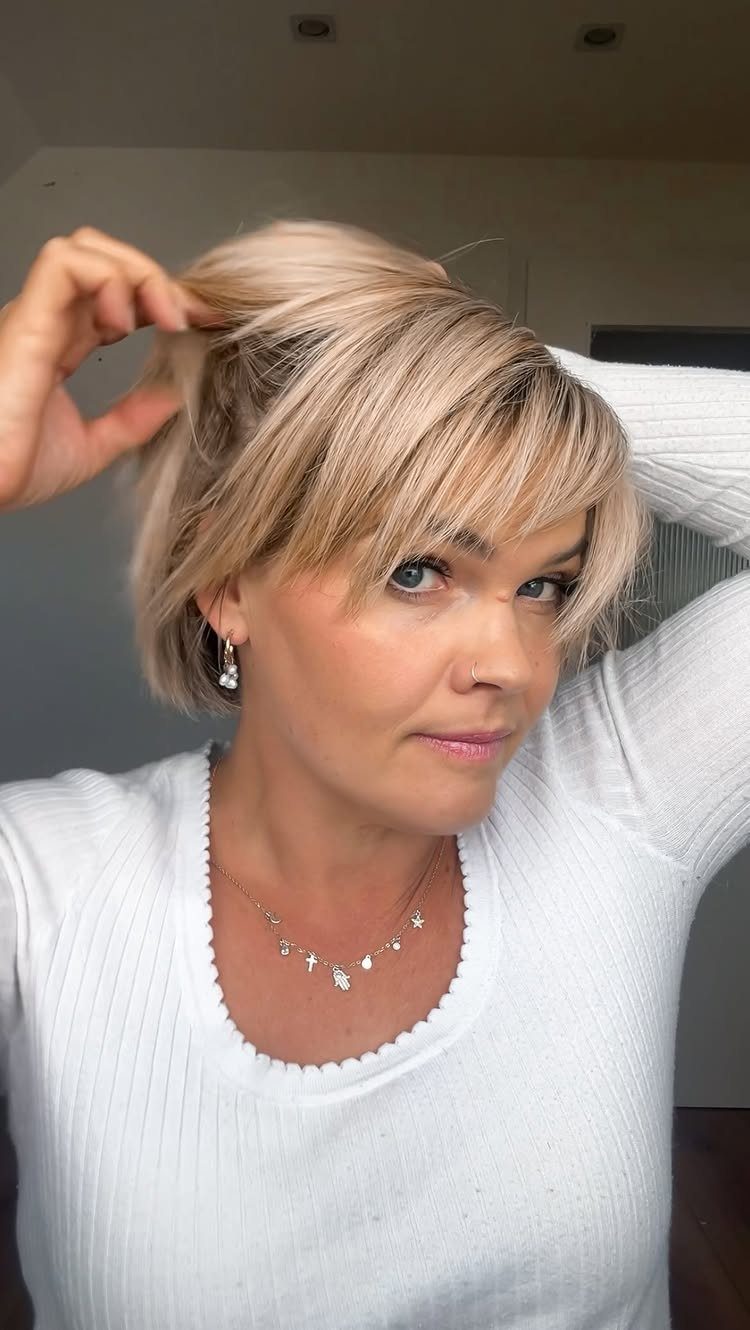 Woman with blonde bob and long face-framing layers blending into her bangs.