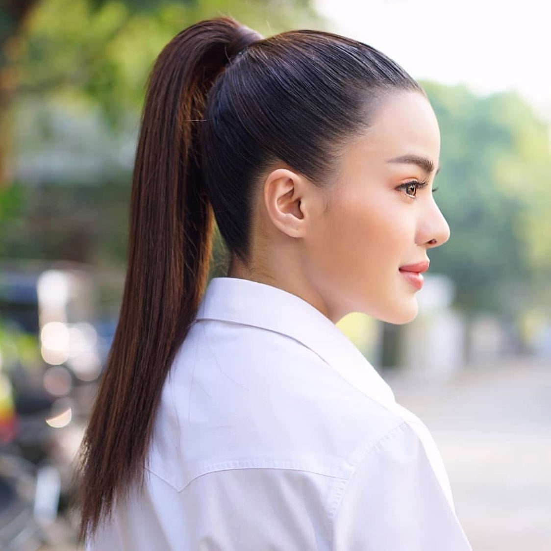 Woman with dark brown hair styled in a sleek, slicked-back high ponytail.