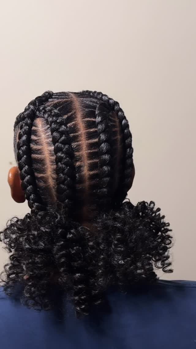 Parallel cornrow braids on a person's head ending in curly black hair.