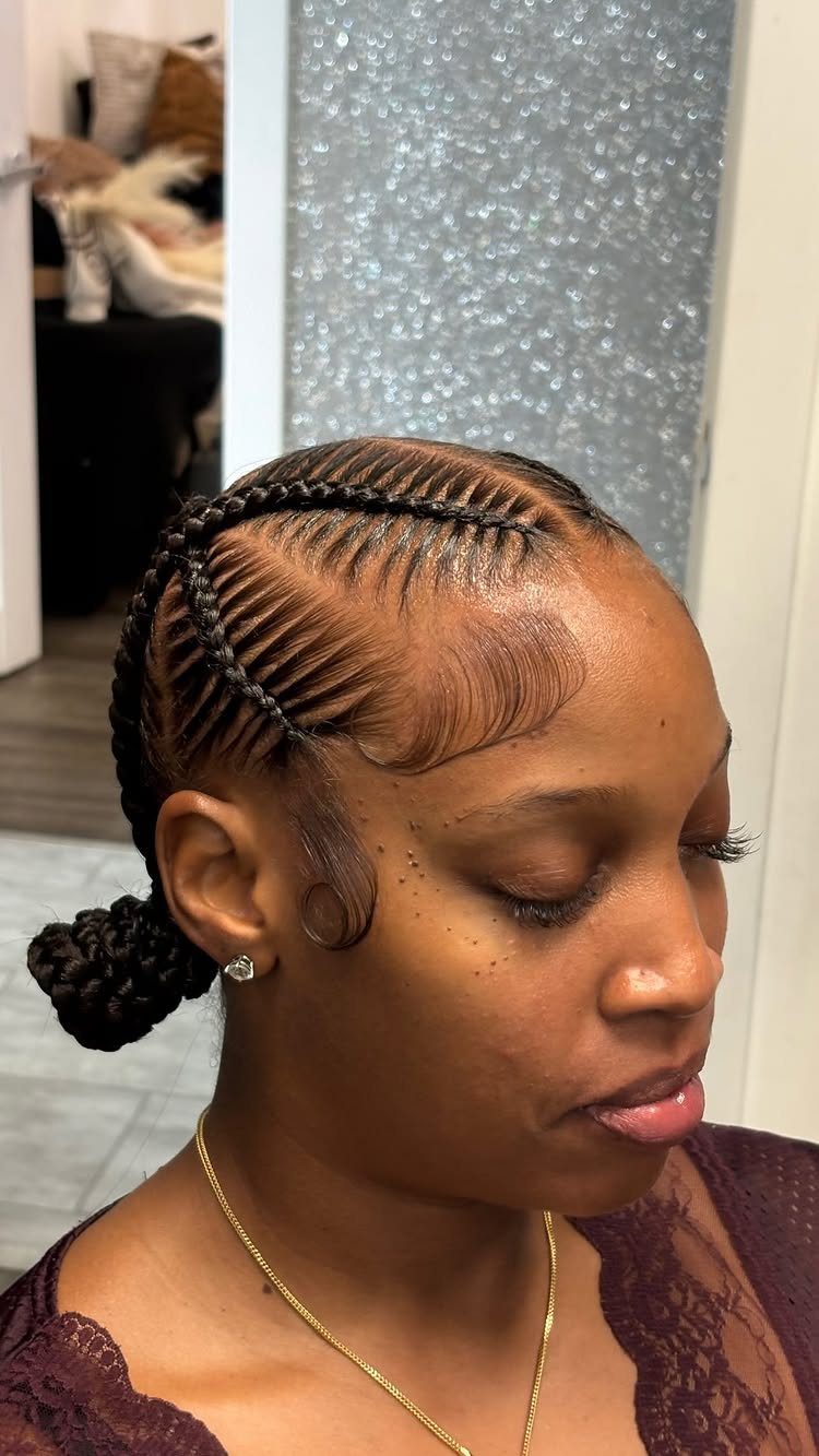 Woman with criss-crossed cornrow braids on her scalp tied into a low bun.