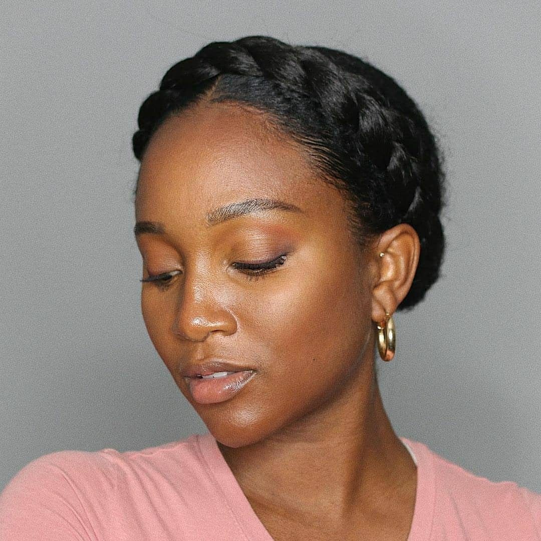 Woman with dark hair styled in a thick crown braid circling her head.