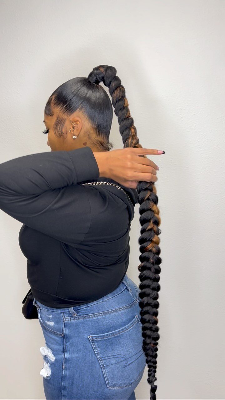 Woman with a high, thick braided ponytail extending down to her waist.