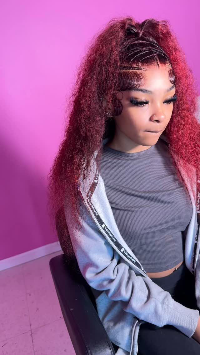 Woman with reddish-brown hair styled in half-up scalp braids and loose curls.