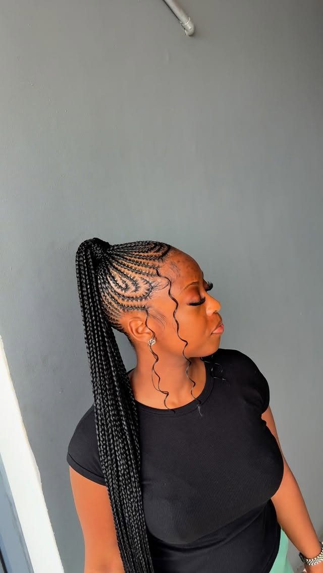 Woman with cornrows leading into a high ponytail of long black box braids.