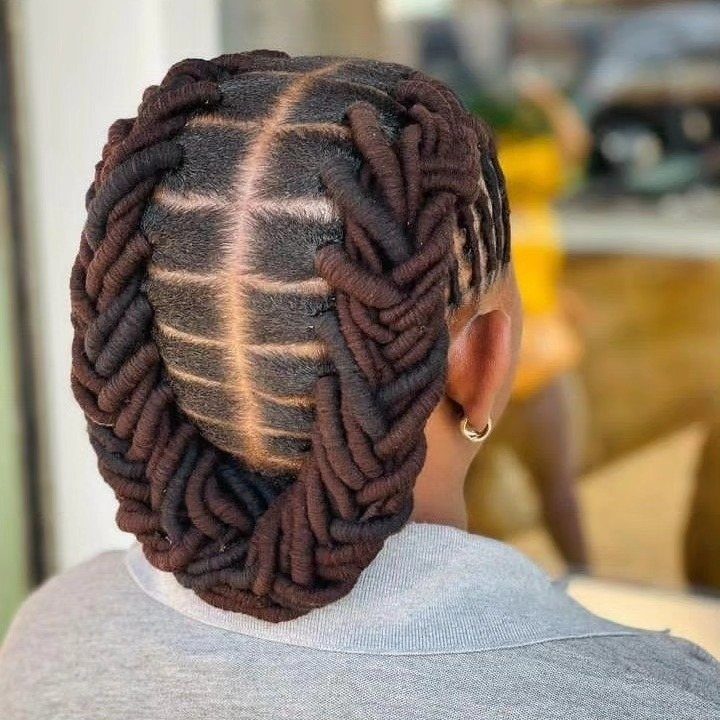Dark brown rope braids styled in a curved pattern on a person's scalp.