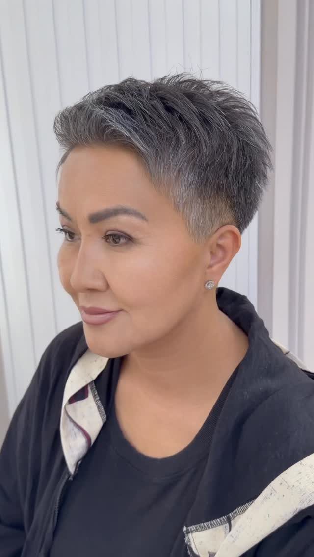 Woman with gray pixie cut featuring tapered sides and textured top layers.