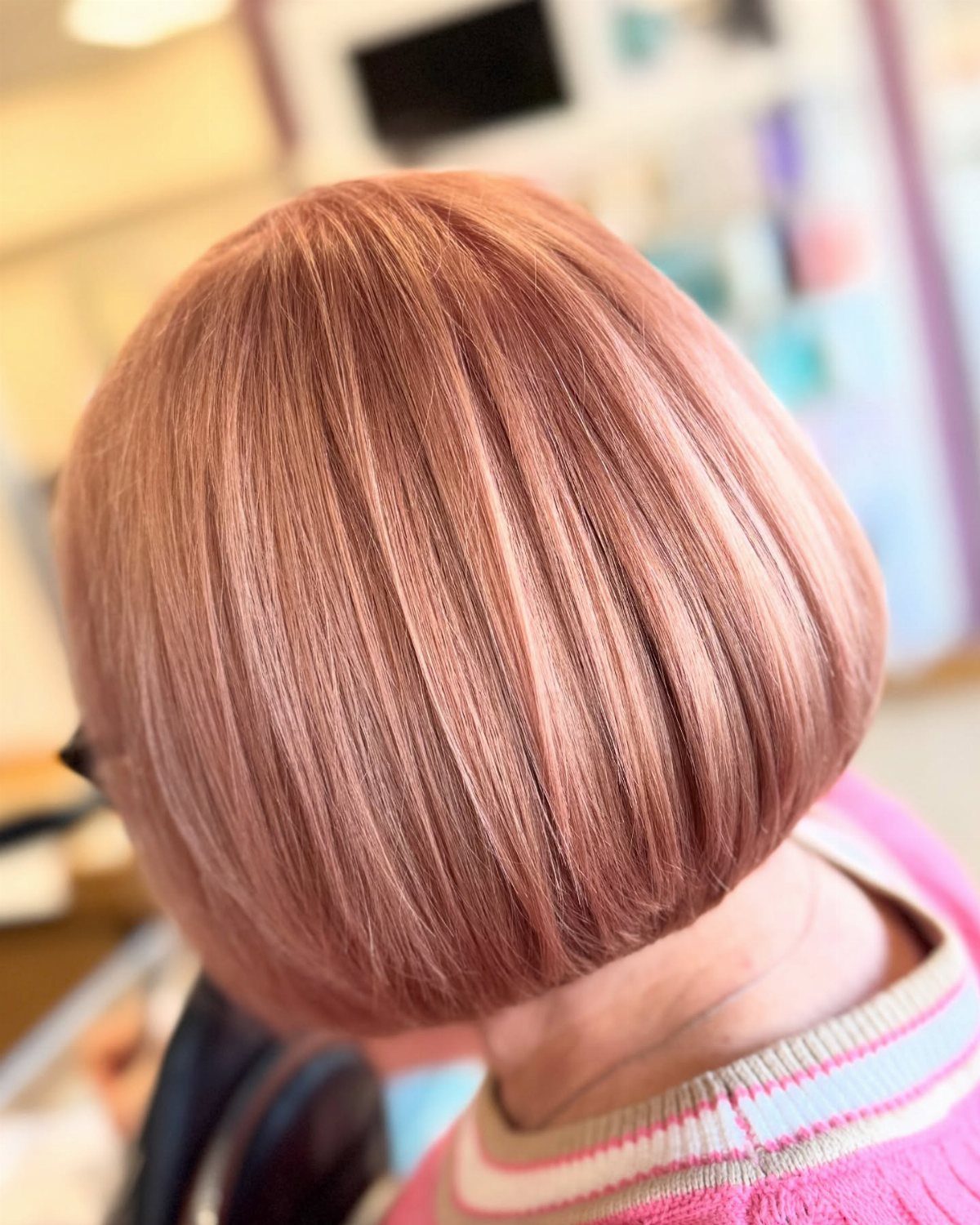 Strawberry blonde bob haircut with dimensional highlights and a blunt cut edge.