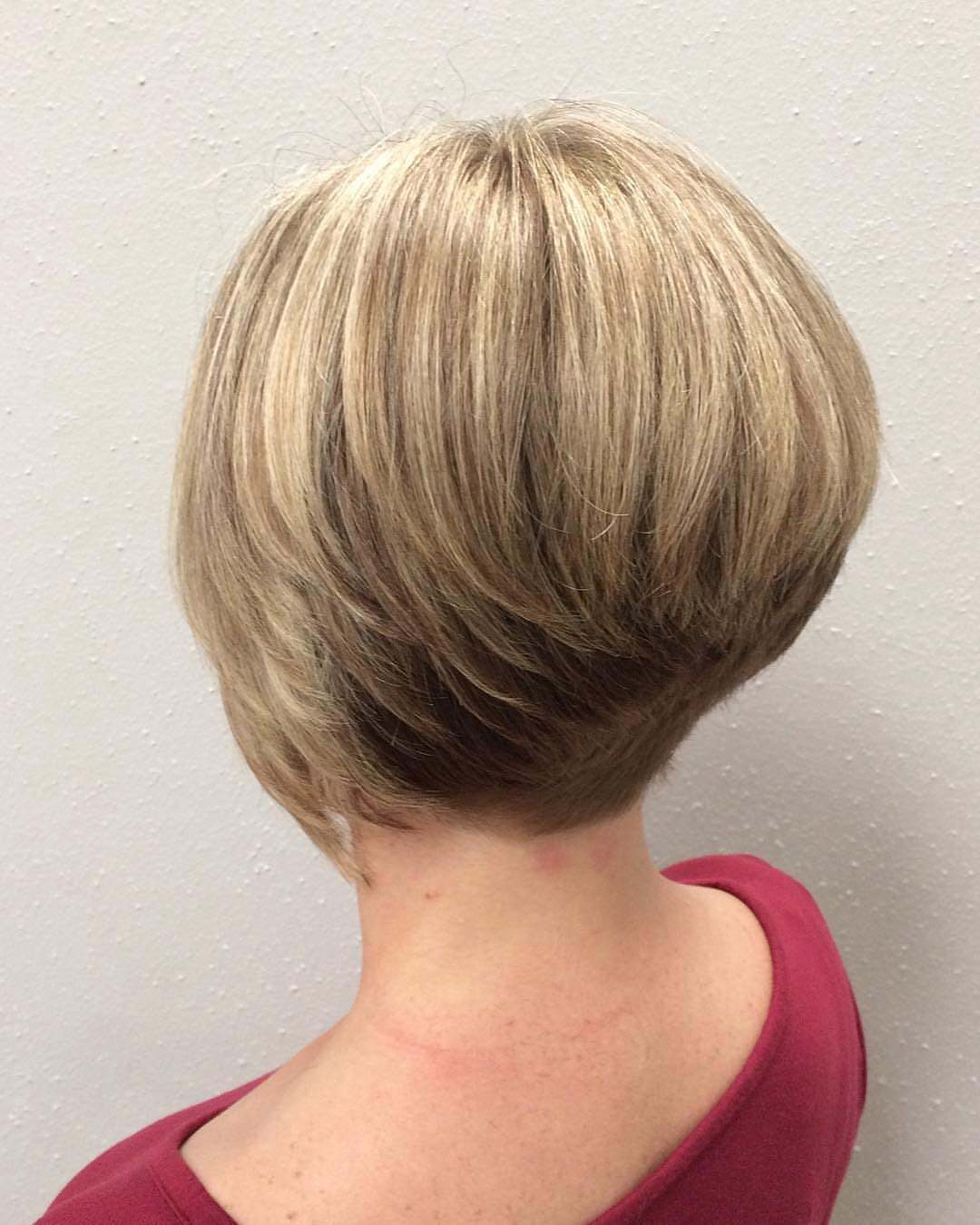 Blonde wedge haircut with a stacked back and angled layers from behind.
