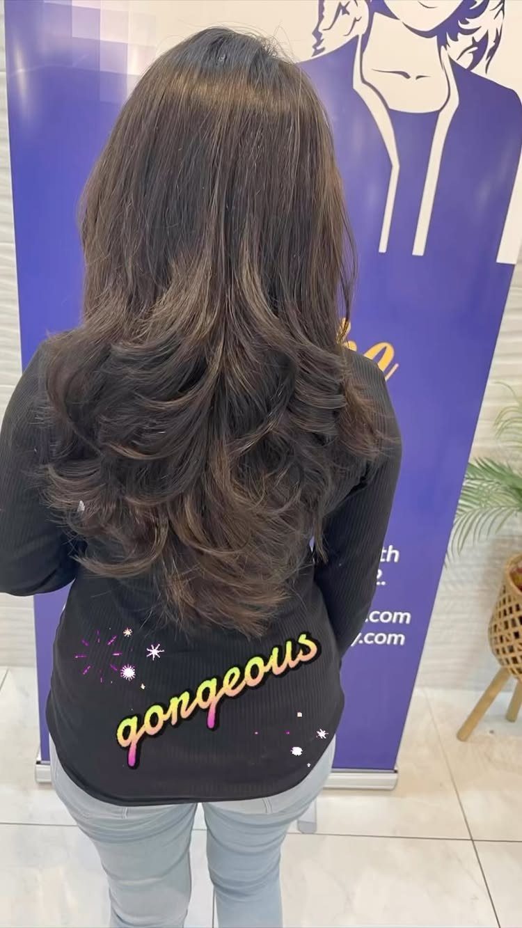 Long brown layered hair with voluminous waves seen from the back.
