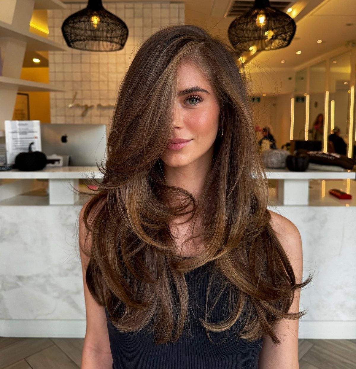 Woman with voluminous mid-length brown hair styled in rounded, outward-curving layers.