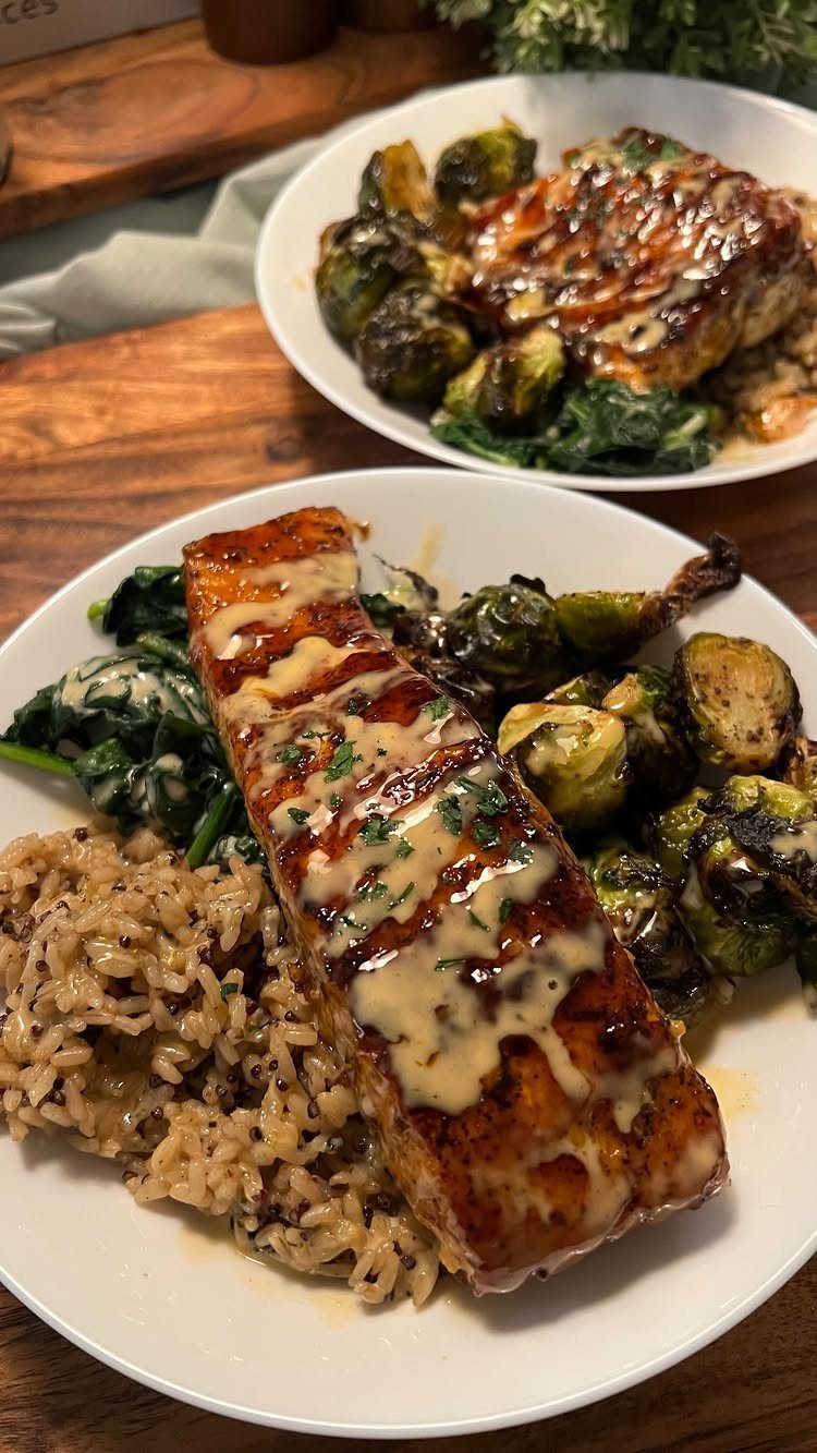Glazed salmon fillets served with brown rice, roasted brussels sprouts, and sautéed spinach.